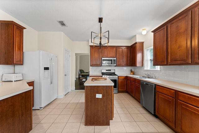 5211 Bur Oak Dr, Pasadena, TX 77505 - kitchen featuring visible vents, a kitchen island, tasteful backsplash, a sink, and stainless steel appliances