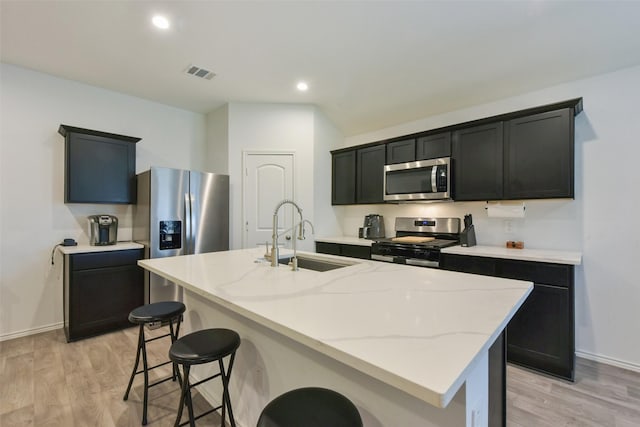 14417 Gray Rocks Rd, Splendora, TX 77372 - kitchen featuring light stone countertops, a sink, baseboards, light wood-style floors, and stainless steel appliances