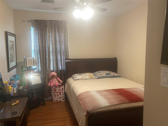 bedroom featuring ceiling fan, visible vents, and wood finished floors