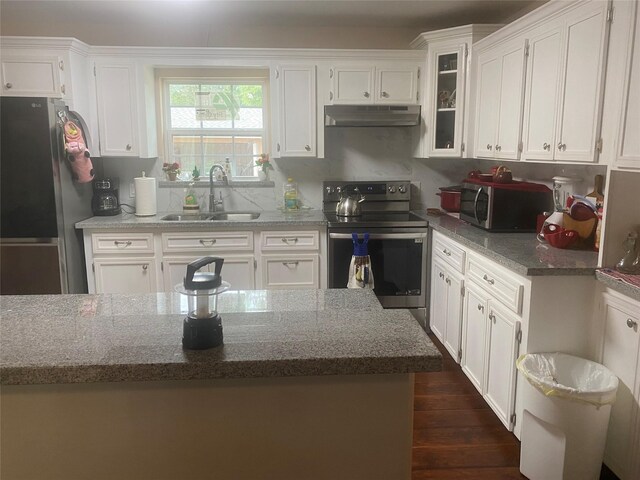 kitchen with appliances with stainless steel finishes, a sink, stone counters, under cabinet range hood, and white cabinetry