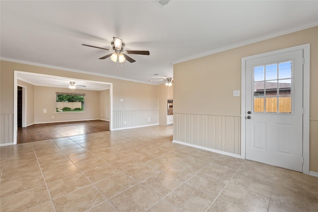 unfurnished room featuring ornamental molding, wainscoting, ceiling fan, and light tile patterned floors