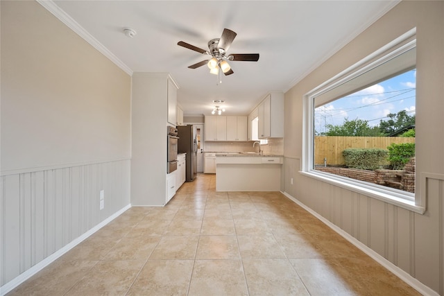 kitchen featuring a peninsula, light countertops, a ceiling fan, appliances with stainless steel finishes, and a warming drawer