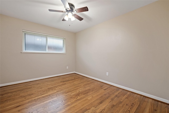 empty room featuring baseboards, ceiling fan, and wood finished floors