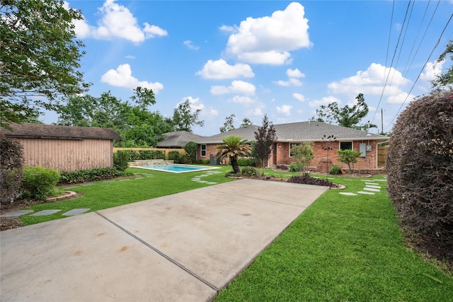 view of yard featuring concrete driveway, fence, a fenced in pool, and a patio area