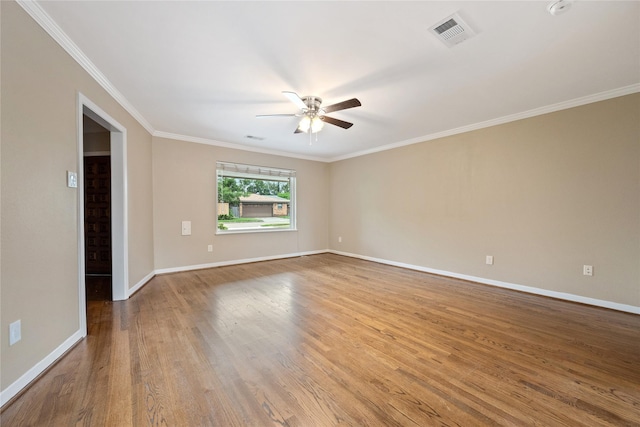 empty room featuring a ceiling fan, baseboards, visible vents, and wood finished floors