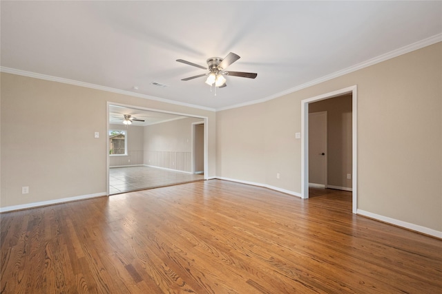 empty room featuring baseboards, ornamental molding, a ceiling fan, and wood finished floors