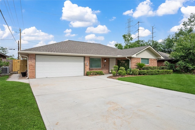 ranch-style house featuring fence, central AC unit, a garage, and brick siding