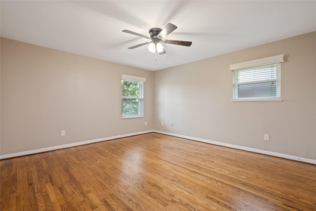 spare room featuring baseboards, ceiling fan, and light wood-type flooring