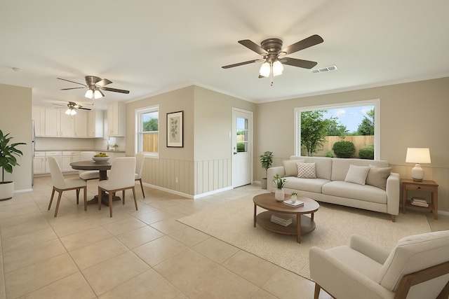 living area with a wealth of natural light, ceiling fan, and visible vents