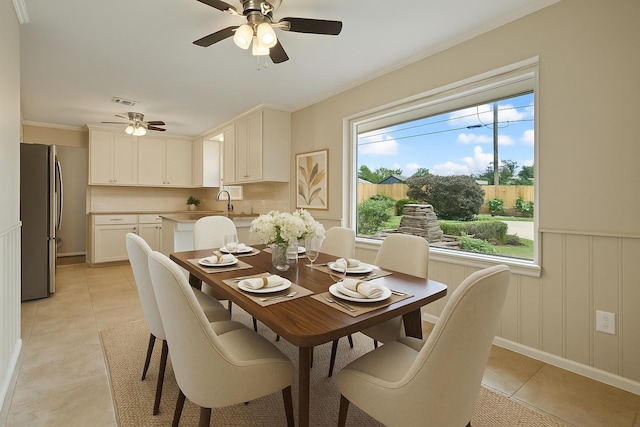 dining space with visible vents, crown molding, baseboards, a ceiling fan, and light tile patterned floors