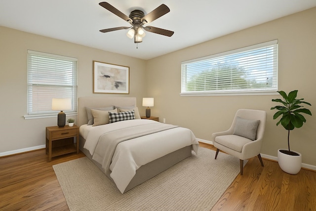 bedroom featuring baseboards, a ceiling fan, and light wood-style flooring