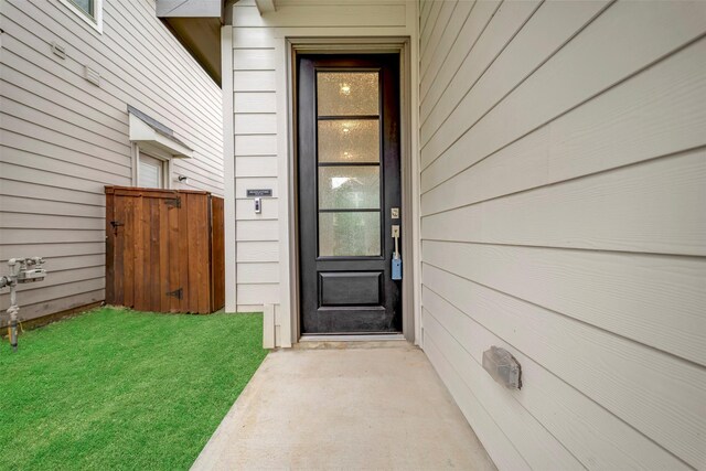 entrance to property with a lawn and fence