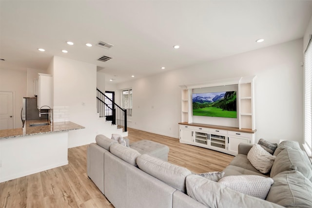 4127 Champlain Way, Iowa Colony, TX 77583 - living room with visible vents, light wood-style flooring, stairway, and recessed lighting