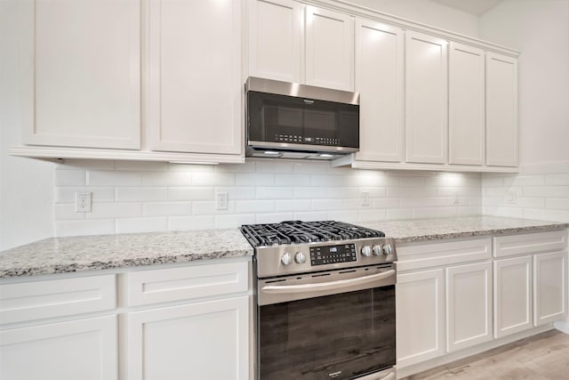4127 Champlain Way, Iowa Colony, TX 77583 - kitchen with white cabinetry, light stone counters, backsplash, and appliances with stainless steel finishes
