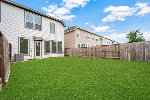 back of property with a lawn, cooling unit, and a fenced backyard