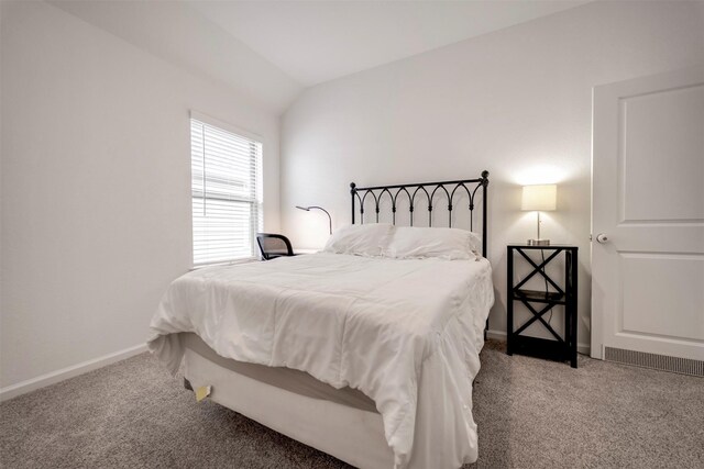 bedroom featuring carpet floors, baseboards, vaulted ceiling, and visible vents