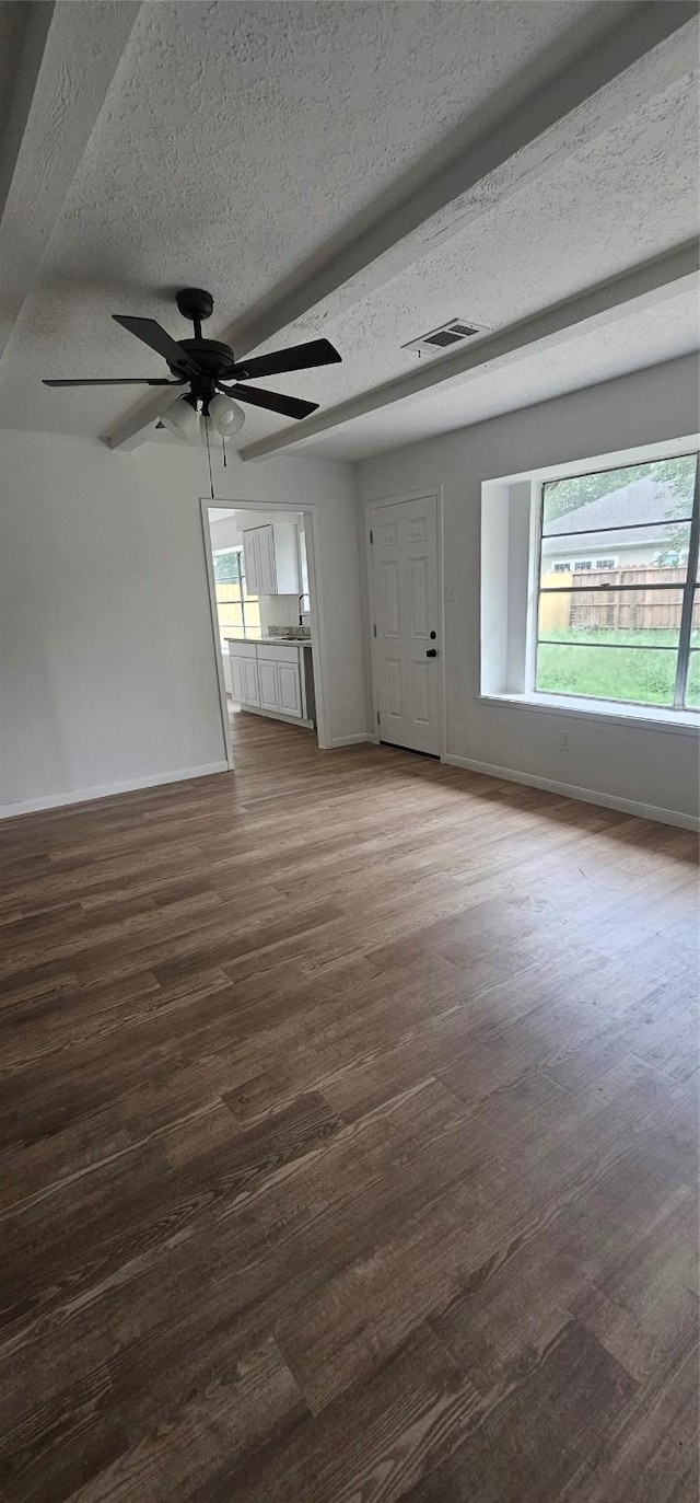 unfurnished living room featuring baseboards, a ceiling fan, wood finished floors, and visible vents