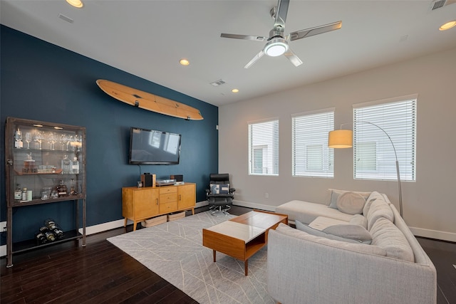 living area featuring baseboards, ceiling fan, wood finished floors, and visible vents