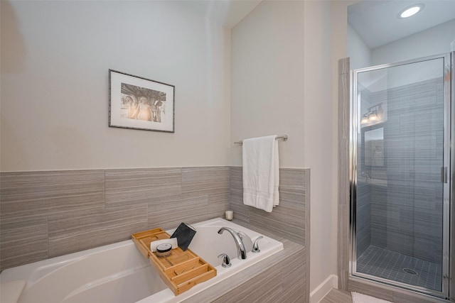 bathroom featuring a bath and a shower stall