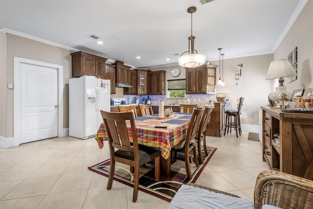 dining room featuring baseboards, visible vents, ornamental molding, and light tile patterned floors