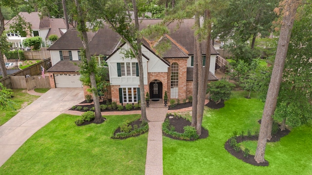 view of front of property with fence, brick siding, a tiled roof, an attached garage, and driveway
