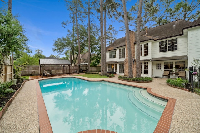 view of swimming pool with a fenced backyard, a fenced in pool, a gazebo, and a patio