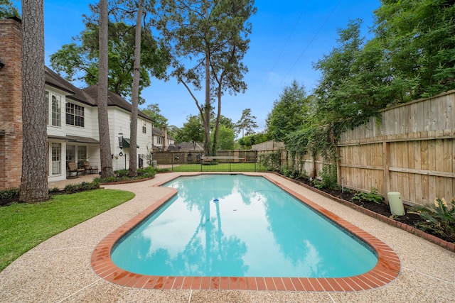 view of pool featuring a fenced backyard, a fenced in pool, a lawn, and a patio