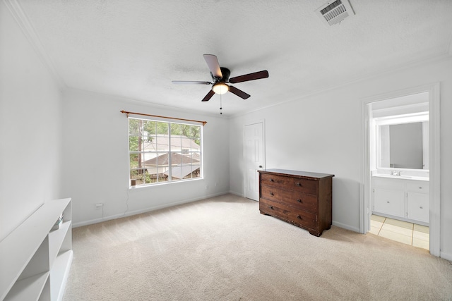 unfurnished bedroom featuring a textured ceiling, carpet, baseboards, visible vents, and ornamental molding