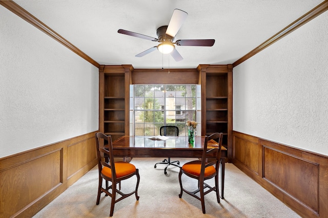 office featuring crown molding, a textured wall, light carpet, and a wainscoted wall