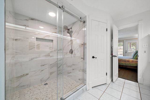 bathroom with a marble finish shower, tile patterned flooring, and ensuite bath