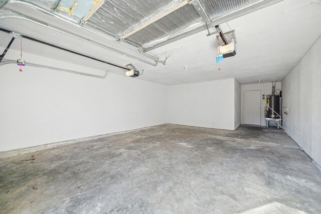 garage featuring water heater and a garage door opener