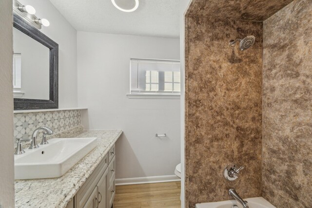 full bathroom featuring vanity, shower / bath combination, baseboards, wood finished floors, and backsplash