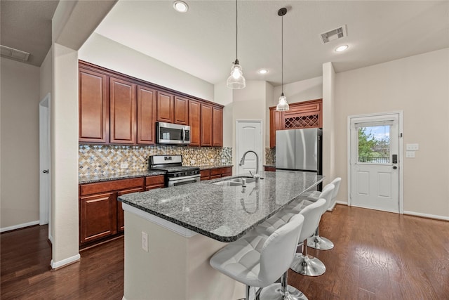 5331 Rue Dela Croix Dr, Katy, TX 77493 - kitchen with a breakfast bar, a sink, stainless steel appliances, decorative backsplash, and visible vents