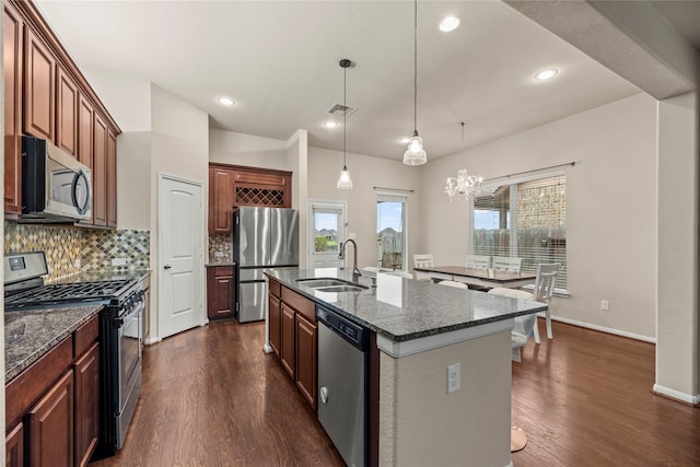 5331 Rue Dela Croix Dr, Katy, TX 77493 - kitchen with a sink, stainless steel appliances, tasteful backsplash, a center island with sink, and dark wood-type flooring