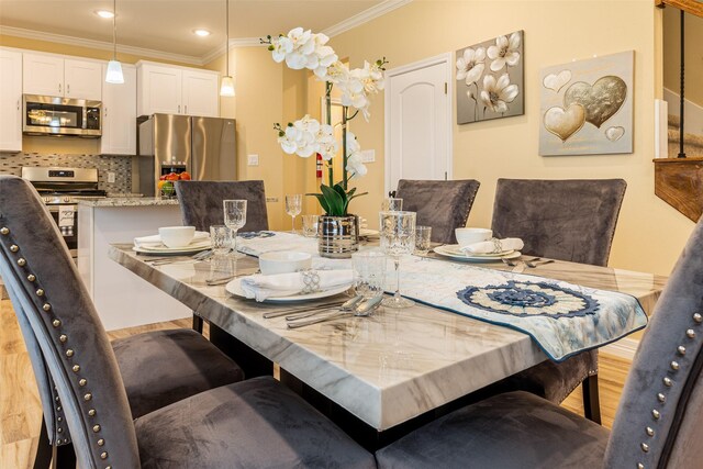 dining space with crown molding, recessed lighting, and light wood-type flooring