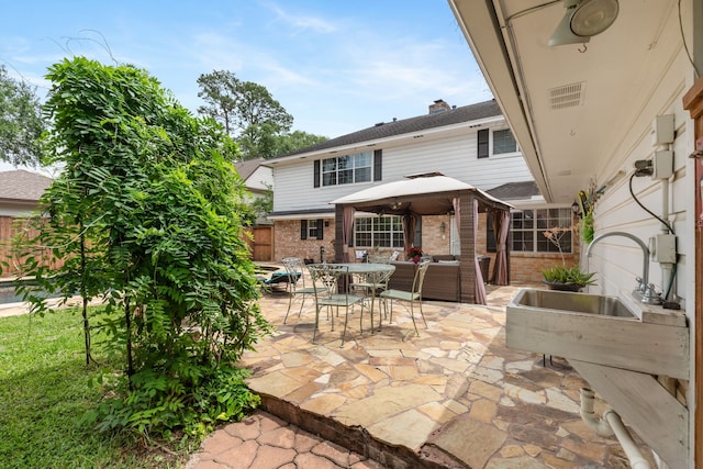 view of patio with a gazebo, fence, and outdoor lounge area