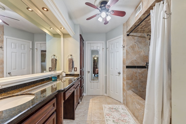 bathroom featuring tiled shower / bath combo, ceiling fan, a sink, and double vanity
