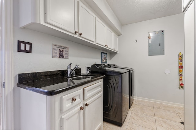 washroom with baseboards, a sink, electric panel, washer and clothes dryer, and cabinet space