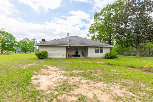back of property with a yard and a patio area
