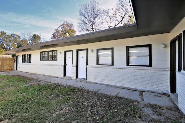 exterior space with brick siding and fence