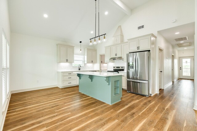 kitchen featuring visible vents, light countertops, appliances with stainless steel finishes, and a breakfast bar area