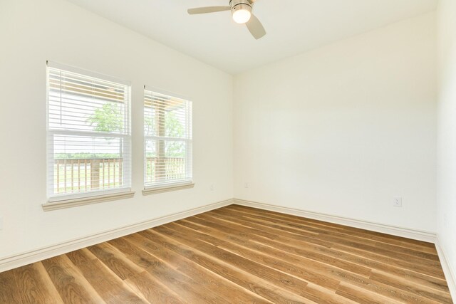 spare room with a ceiling fan, baseboards, and wood finished floors