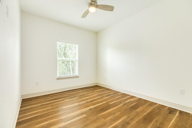 unfurnished room with baseboards, ceiling fan, and wood finished floors