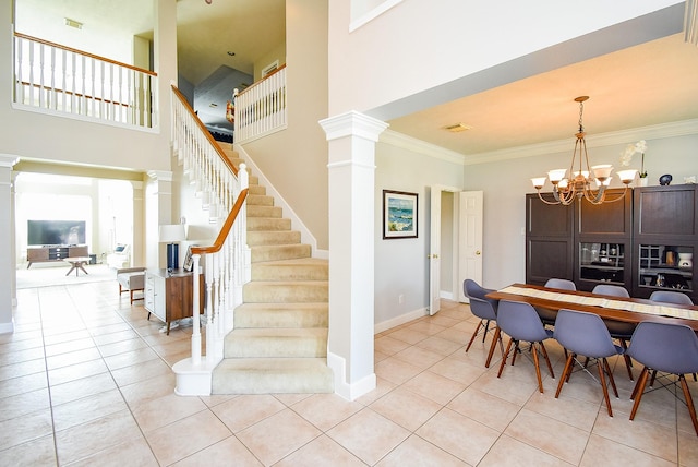 dining room with stairway, a notable chandelier, ornamental molding, ornate columns, and light tile patterned flooring