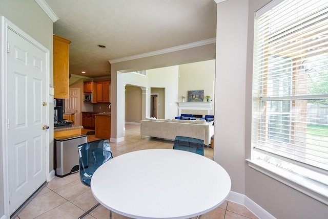dining room featuring plenty of natural light, ornamental molding, baseboards, and light tile patterned floors
