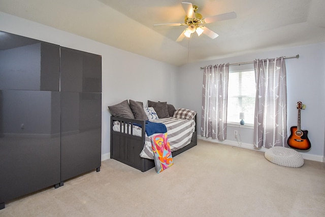 bedroom with light colored carpet, a ceiling fan, and baseboards