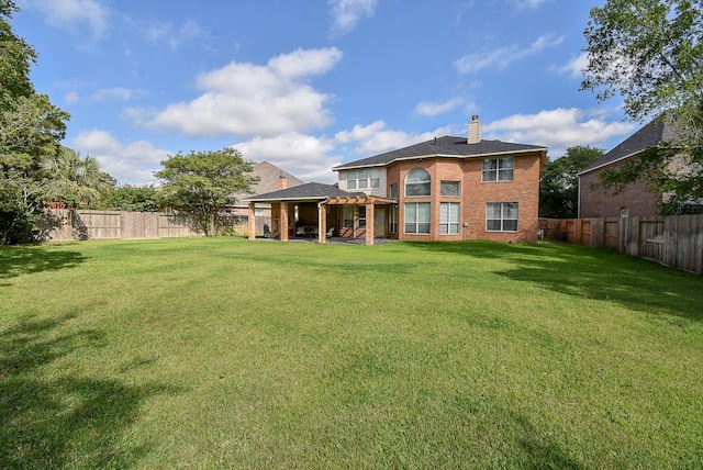 rear view of property featuring a lawn, brick siding, a chimney, and a fenced backyard