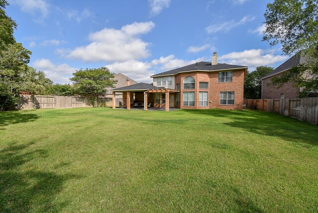 12131 Cielio Bay Ln, Houston, TX 77041 - rear view of property featuring a chimney, brick siding, and a patio area