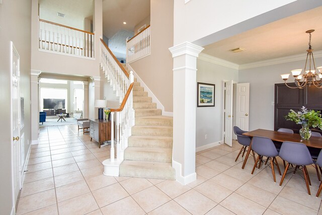 12131 Cielio Bay Ln, Houston, TX 77041 - stairway with decorative columns, tile patterned floors, a chandelier, baseboards, and crown molding