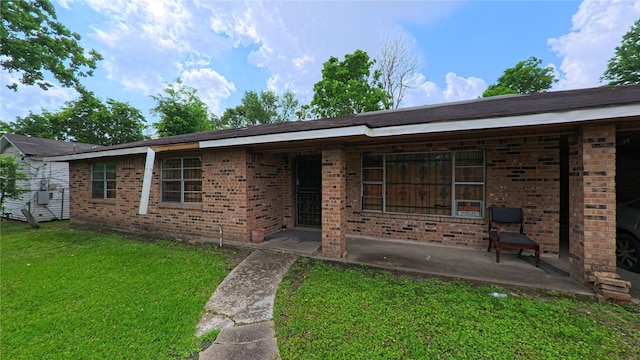 view of front facade featuring brick siding and a front yard